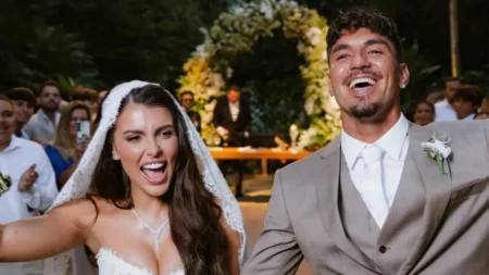 Isabella Arantes e Gabriel Medina aparecem sorrindo durante a cerimônia de casamento, realizada em meio à natureza.