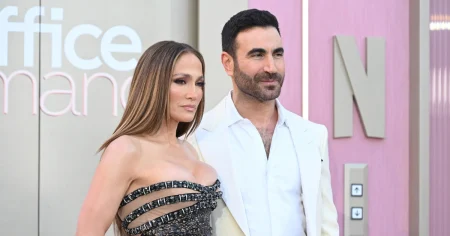 Jennifer Lopez deixa festa com suposto affair e reacende boatos de romance Jennifer Lopez posa ao lado de Brett Goldstein em evento, usando vestido preto com detalhes brilhantes, enquanto o ator veste terno branco