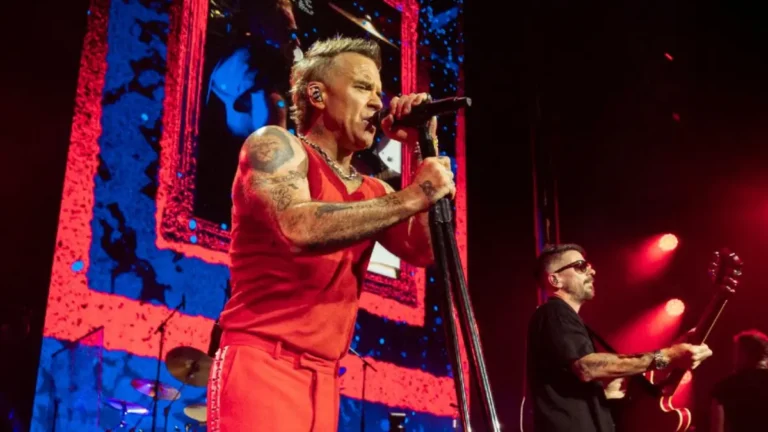Robbie Williams volta ao Brasil após 20 anos e alfineta Rock in Rio; veja Robbie Williams aparece em dois momentos durante show, com figurino vermelho e performance no palco.