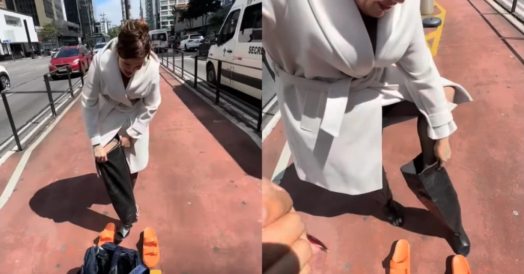 Thais Carla aparece de casaco branco enquanto tenta calçar botas pretas na ciclovia da Avenida Paulista, em São Paulo