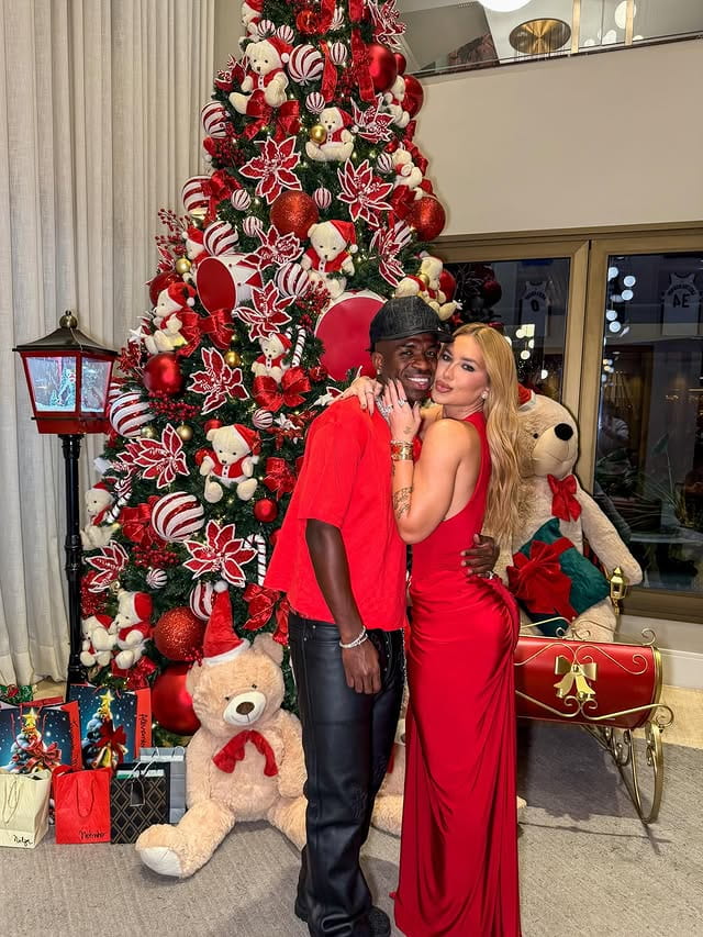 Virginia Fonseca, Ludmilla e Mariah Carey: 9 momentos do Natal de 2025 1 Virginia Fonseca posa ao lado de Vini Jr. em frente a uma árvore de Natal decorada em tons de vermelho, com presentes e ursinhos espalhados pelo ambiente, durante celebração em família.